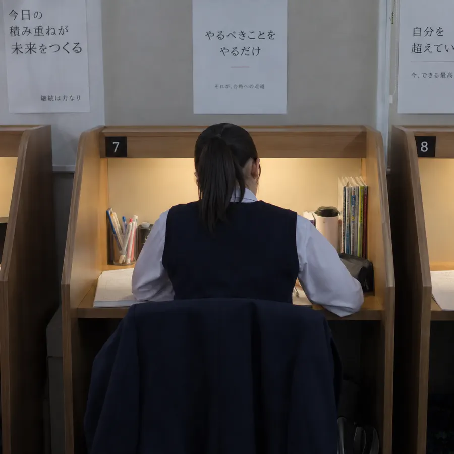 自習室の仕切りのある席で勉強する生徒の後ろ姿