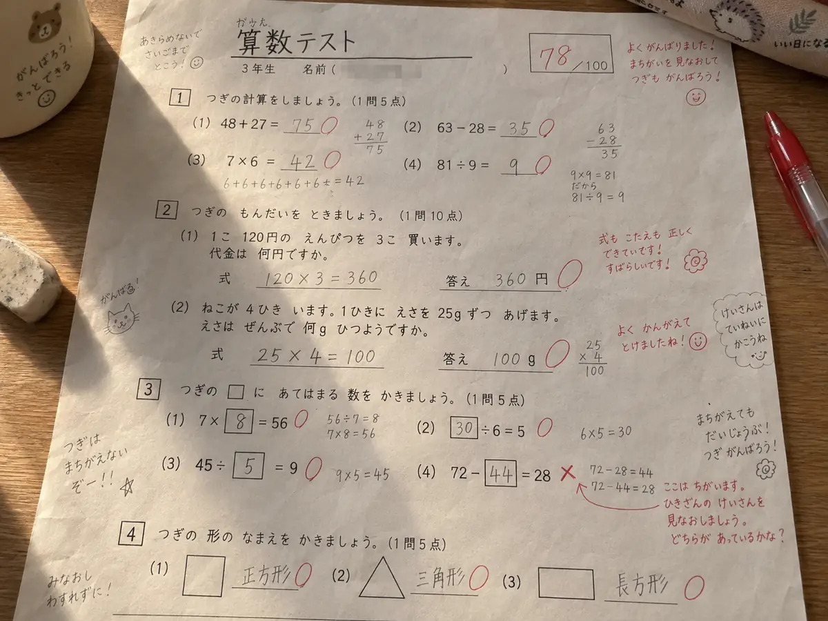 赤ペンで訂正と短い文章が書き込まれた算数の答案用紙